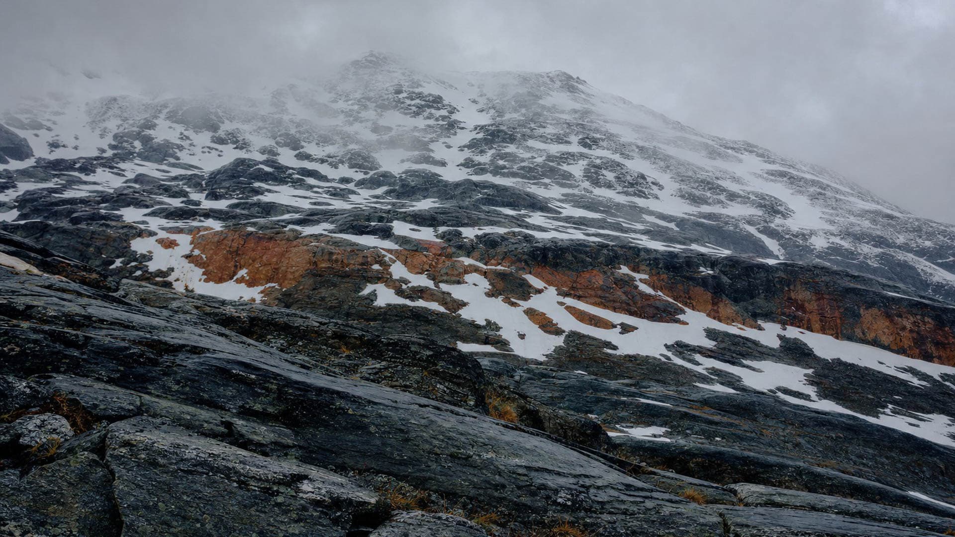 A mountain ridge with cloud closing over it