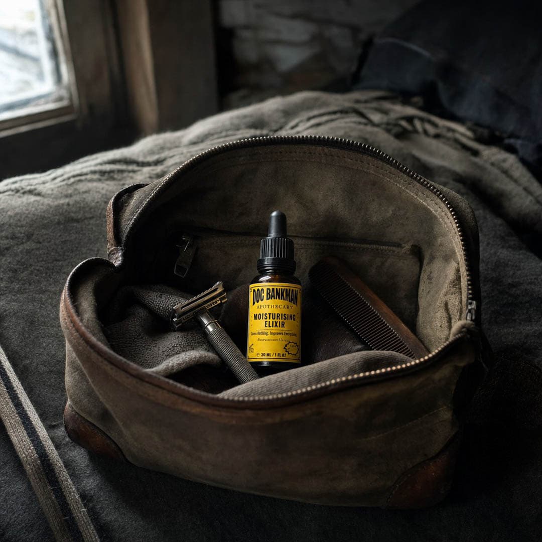 A canvas washbag open on a wooden surface, the amber bottle packed among plain travel things