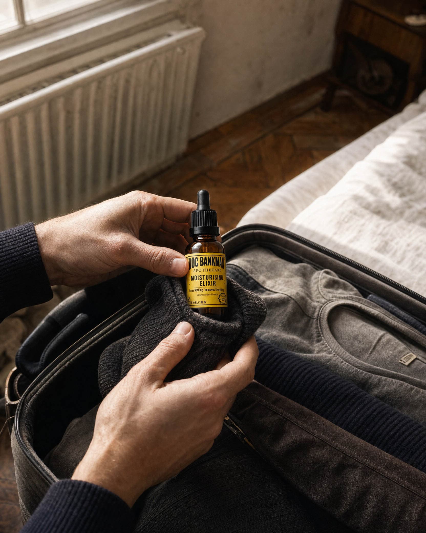 Hands packing the bottle into a sock inside an open suitcase