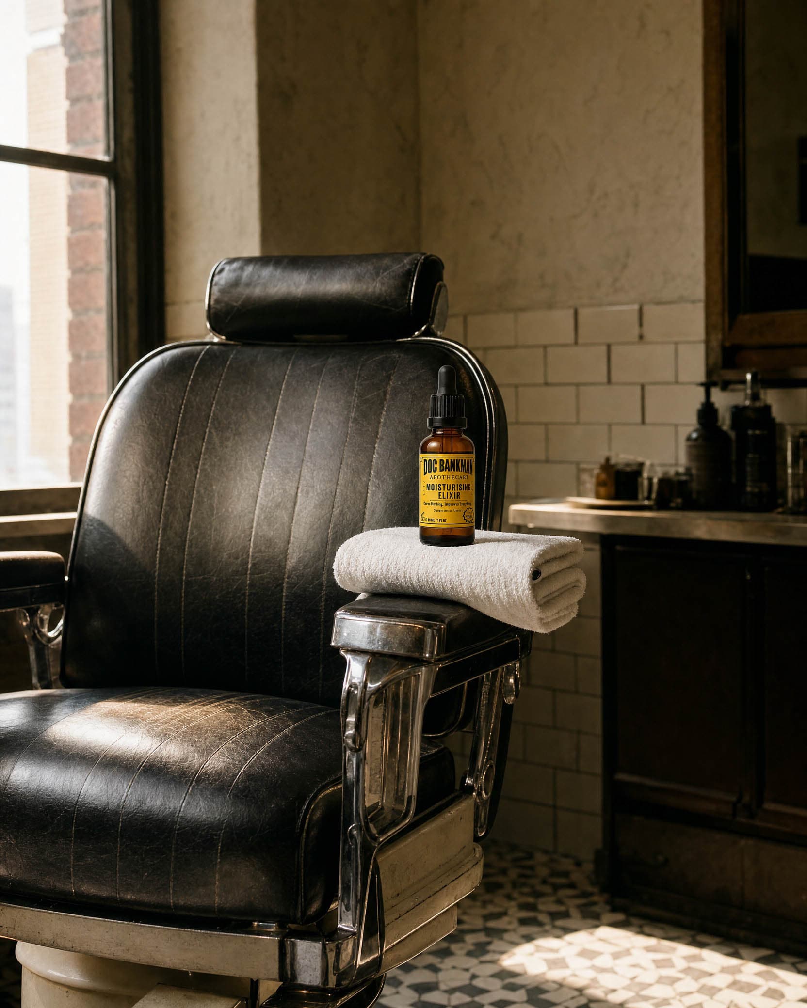 An empty barber's chair, a folded towel and the bottle on the armrest
